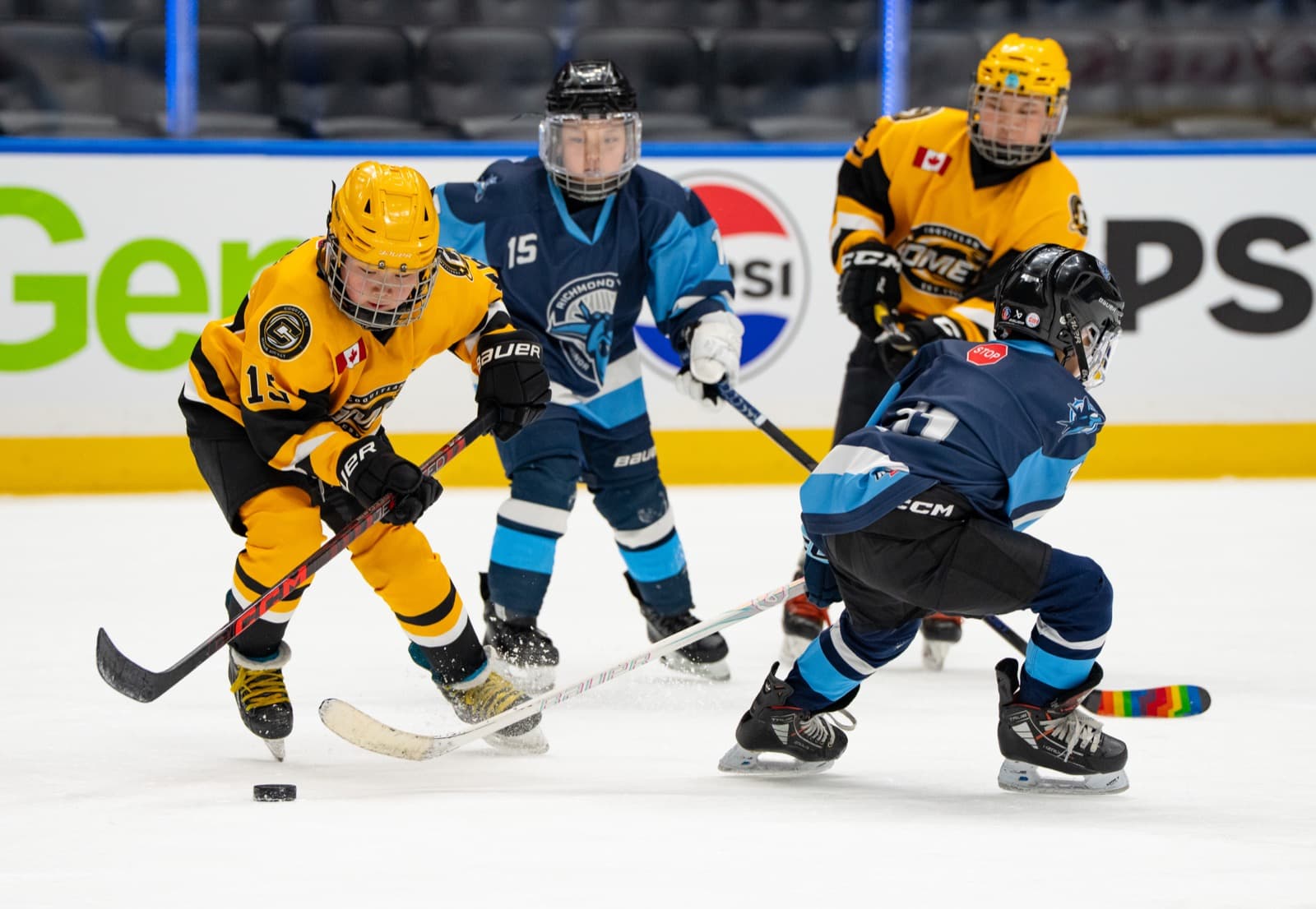 A Comets forward battles a Richmond Jets defender for the puck along the boards