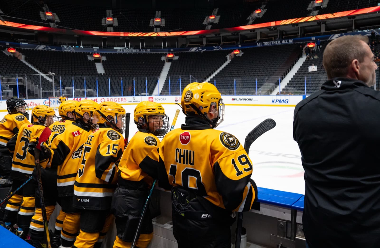 Comets players lined up on the bench watching the action unfold on the Rogers Arena ice