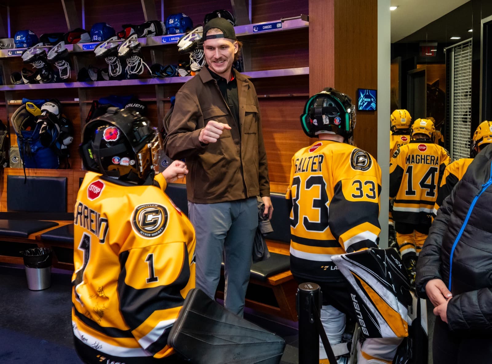 Curtis Douglas fist-bumping young Comets players in the Canucks dressing room