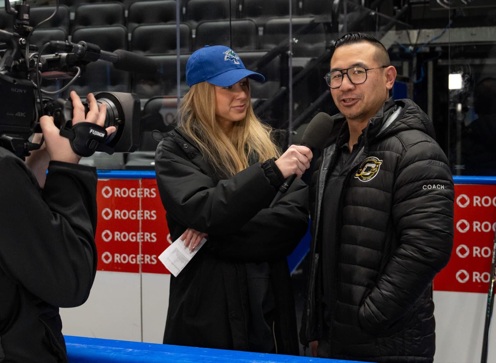Head coach Athen Yuen being interviewed rinkside during warmups at Rogers Arena