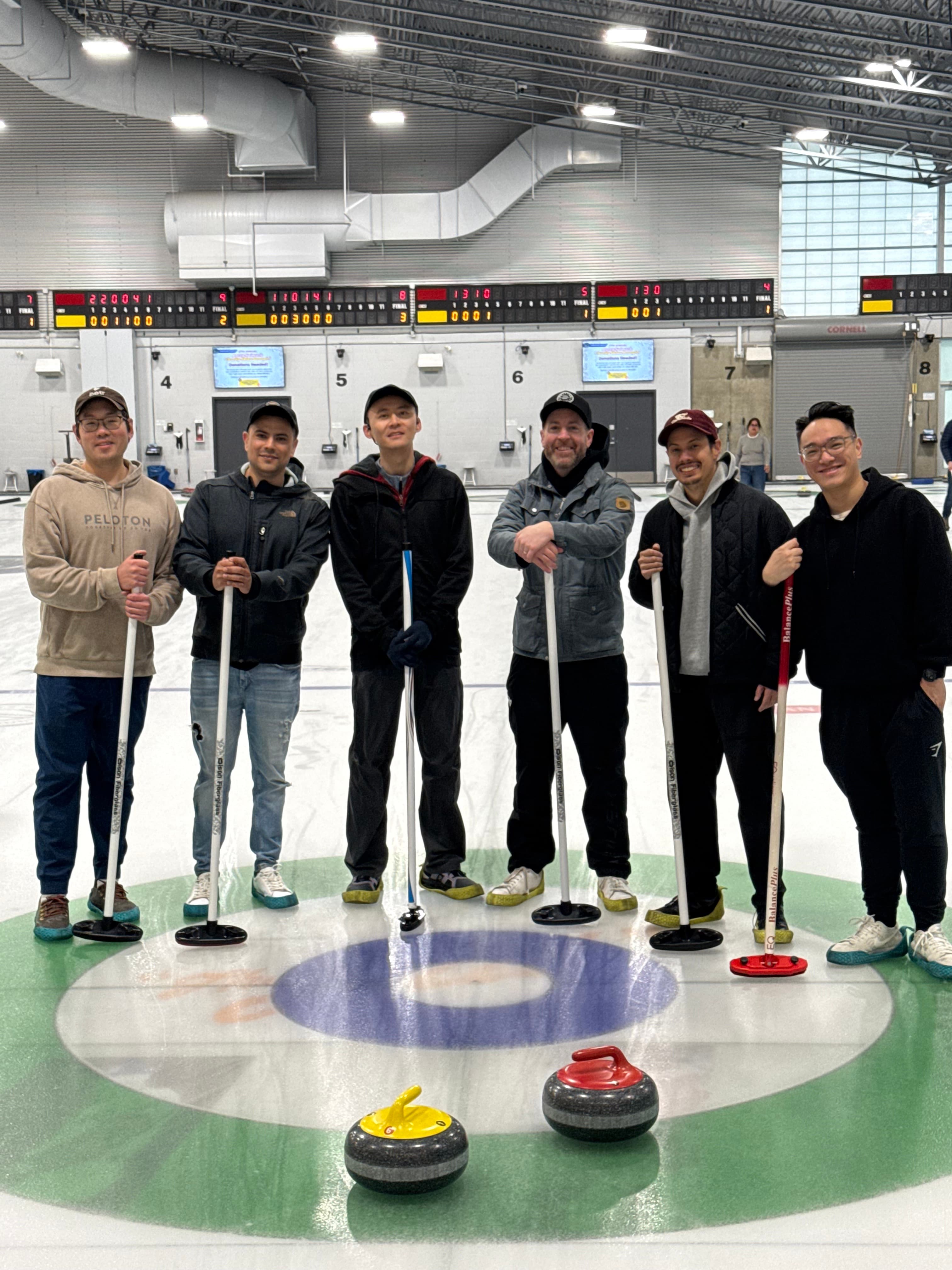 A smaller group of team members posing together on the curling rink